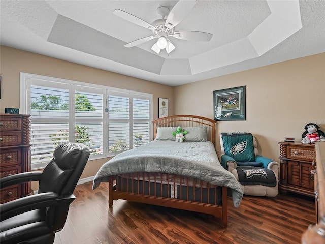 2998 Kramer Ct, The Villages, FL 32163 - bedroom with a tray ceiling, multiple windows, wood finished floors, and a ceiling fan