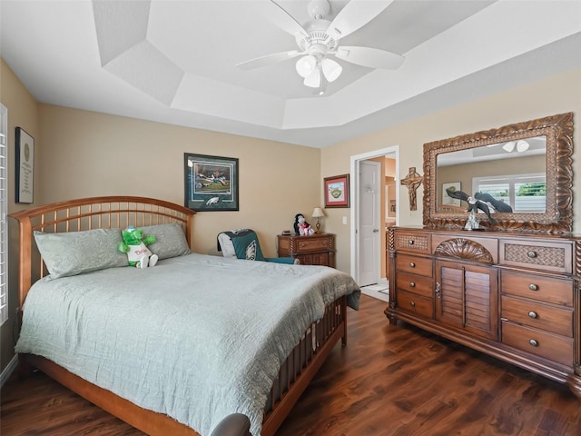 2998 Kramer Ct, The Villages, FL 32163 - bedroom with a raised ceiling, dark wood-style flooring, and ceiling fan