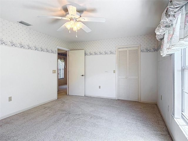 6147 N Whispering Oak Loop, Beverly Hills, FL 34465 - unfurnished bedroom with wallpapered walls, carpet flooring, a ceiling fan, a closet, and baseboards