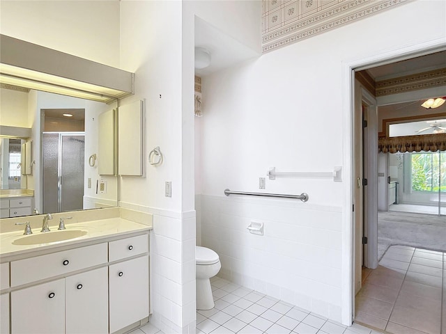6147 N Whispering Oak Loop, Beverly Hills, FL 34465 - bathroom with a shower stall, tile patterned flooring, vanity, toilet, and a wainscoted wall