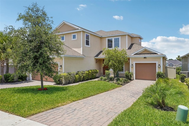 view of front of home with decorative driveway, stucco siding, a front lawn, a garage, and a shingled roof