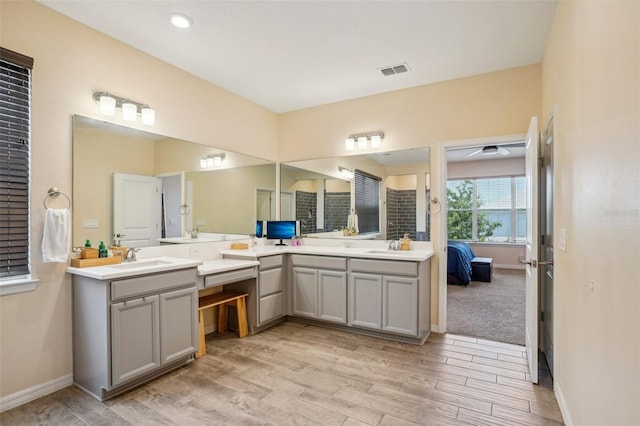 full bath featuring vanity, wood finished floors, connected bathroom, and baseboards