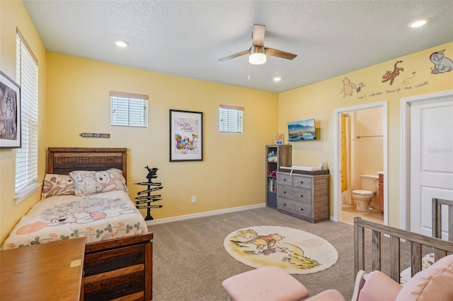 carpeted bedroom featuring recessed lighting, baseboards, a textured ceiling, ensuite bath, and ceiling fan