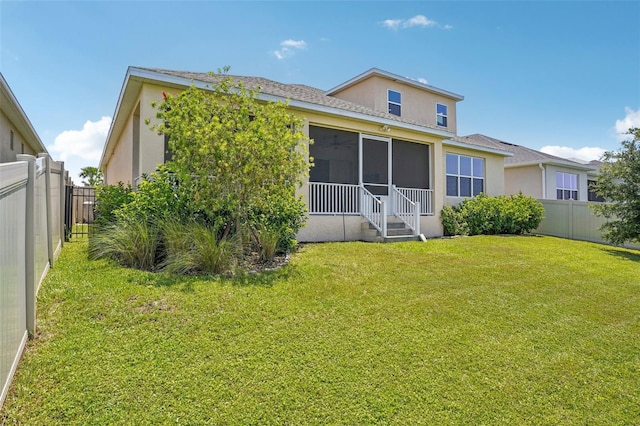 back of property with stucco siding and a sunroom