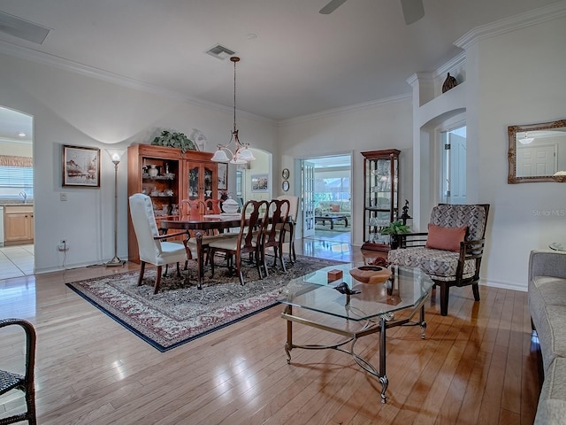 3112 Burbank Ln, The Villages, FL 32162 - living room with light wood-style flooring, crown molding, baseboards, a ceiling fan, and arched walkways