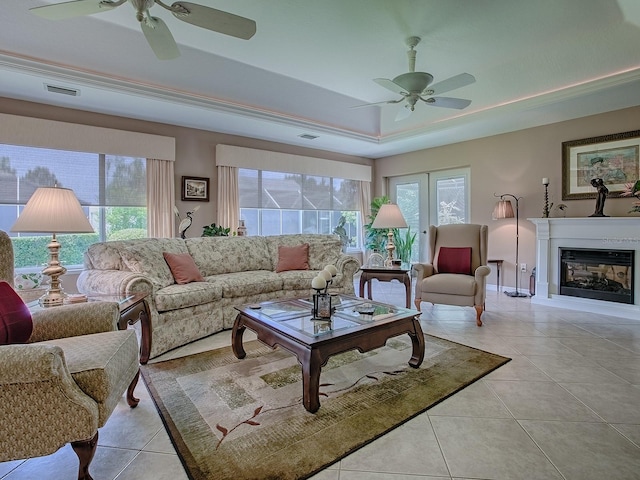 3112 Burbank Ln, The Villages, FL 32162 - living room featuring a ceiling fan, a tray ceiling, light tile patterned floors, and healthy amount of natural light