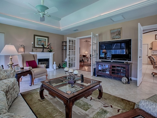 3112 Burbank Ln, The Villages, FL 32162 - living room with light tile patterned floors, a ceiling fan, french doors, a raised ceiling, and baseboards