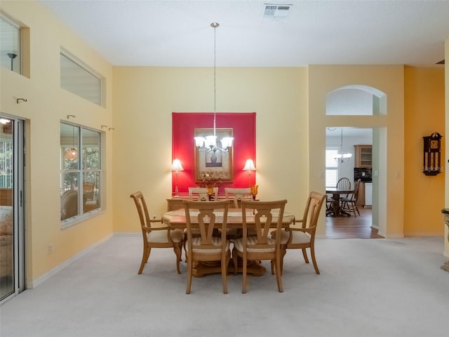 25243 River Crest Dr, Leesburg, FL 34748 - dining area with a chandelier, carpet flooring, baseboards, and a high ceiling