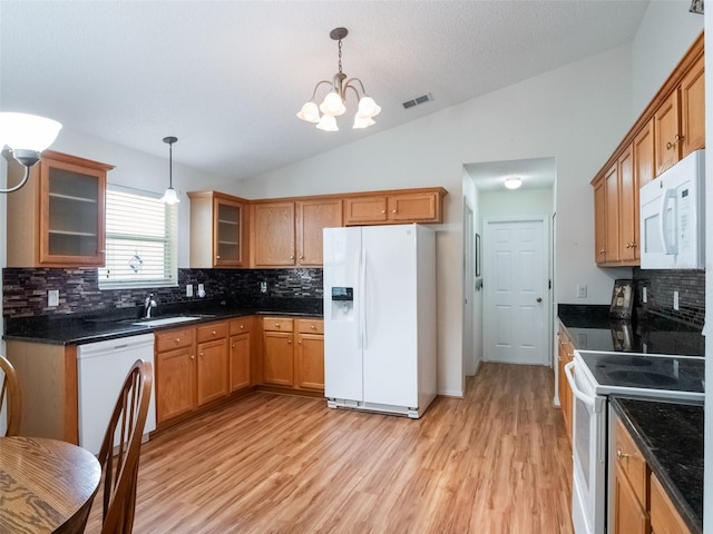 25243 River Crest Dr, Leesburg, FL 34748 - kitchen featuring white appliances, lofted ceiling, a chandelier, light wood-style floors, and decorative backsplash
