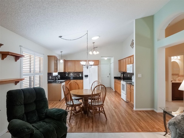 25243 River Crest Dr, Leesburg, FL 34748 - dining area with light wood-type flooring, lofted ceiling, a chandelier, and a textured ceiling