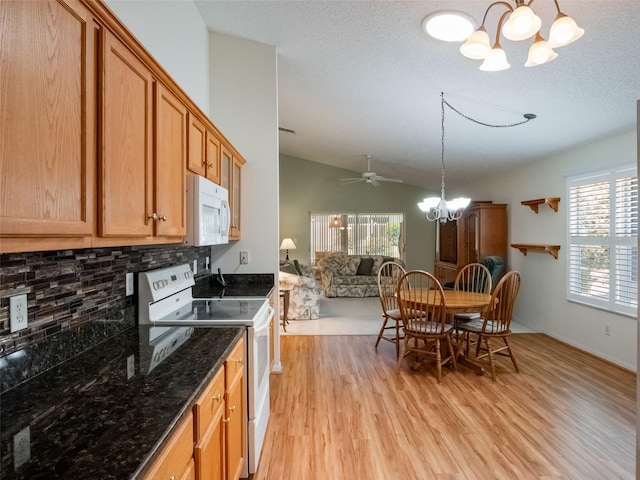 25243 River Crest Dr, Leesburg, FL 34748 - kitchen with white appliances, a chandelier, lofted ceiling, light wood-style floors, and backsplash