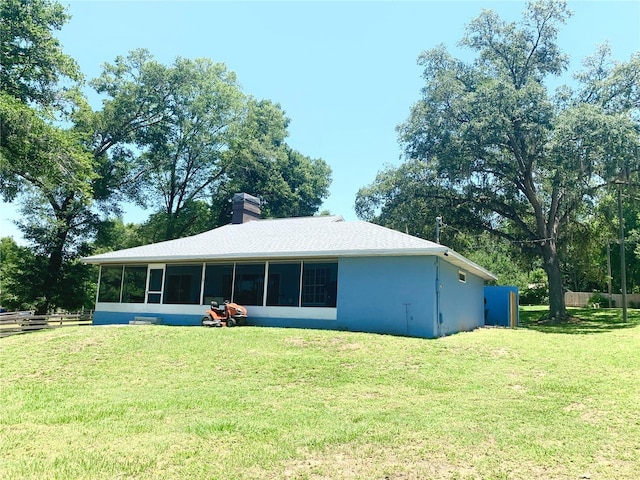 8180 N Duval Dr, Citrus Springs, FL 34434 - rear view of house with a sunroom, a chimney, and stucco siding