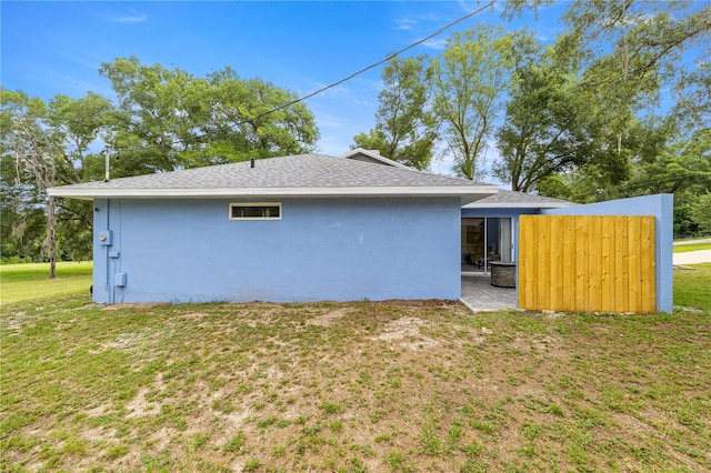 8180 N Duval Dr, Citrus Springs, FL 34434 - view of property exterior featuring stucco siding, a yard, and a shingled roof