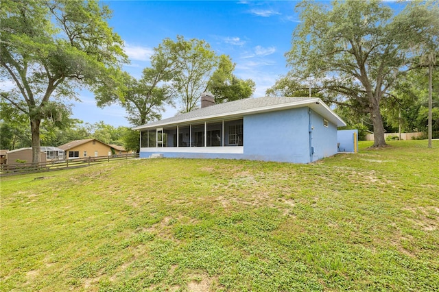 8180 N Duval Dr, Citrus Springs, FL 34434 - rear view of property featuring a sunroom, a chimney, and stucco siding
