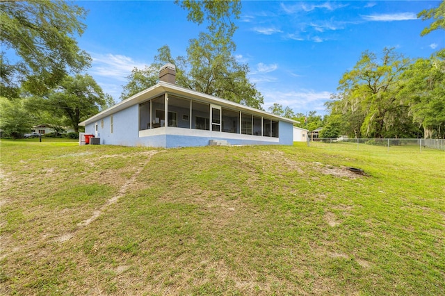 8180 N Duval Dr, Citrus Springs, FL 34434 - rear view of house with a sunroom, a chimney, and stucco siding