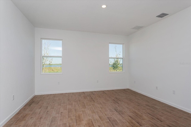 5017 Balsam Falls Rd, Deland, FL 32724 - empty room featuring healthy amount of natural light, light wood-type flooring, baseboards, and recessed lighting