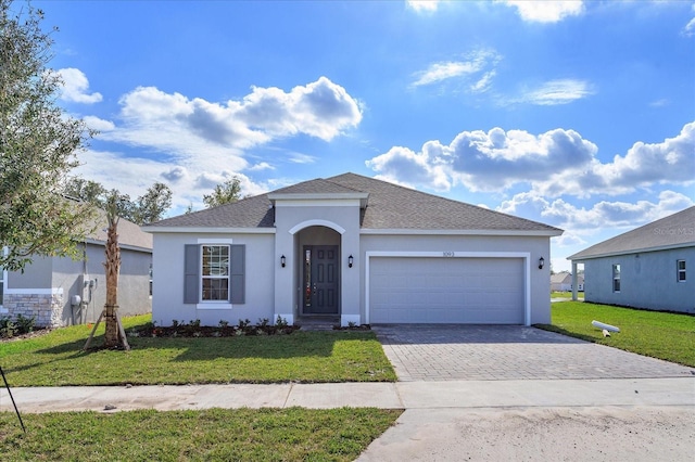 5009 Balsam Falls Rd, Deland, FL 32724 - view of front of property featuring stucco siding, decorative driveway, and a front yard