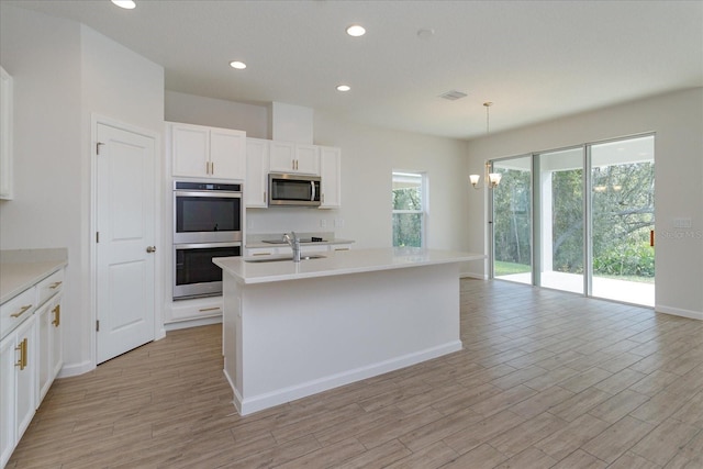 5009 Balsam Falls Rd, Deland, FL 32724 - kitchen with appliances with stainless steel finishes, plenty of natural light, white cabinetry, light wood-type flooring, and recessed lighting