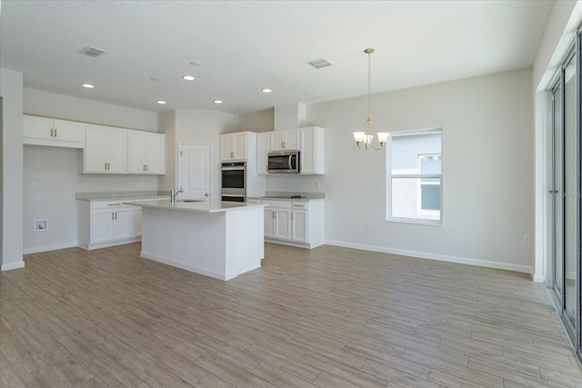 5009 Balsam Falls Rd, Deland, FL 32724 - kitchen featuring stainless steel appliances, a chandelier, white cabinetry, open floor plan, and recessed lighting