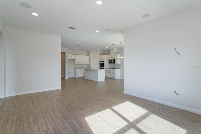 5009 Balsam Falls Rd, Deland, FL 32724 - unfurnished living room featuring light wood-style floors, baseboards, and recessed lighting