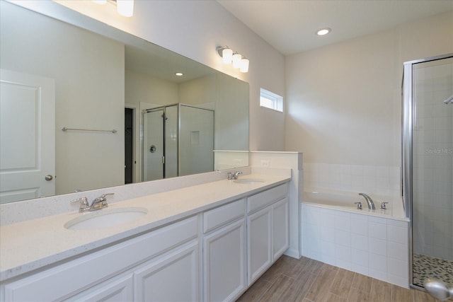 5009 Balsam Falls Rd, Deland, FL 32724 - bathroom featuring a stall shower, a garden tub, double vanity, and wood finished floors