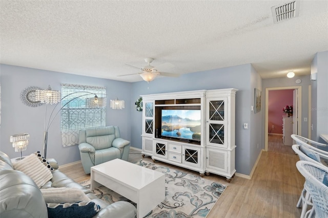 1728 Morelos Rd, The Villages, FL 32159 - living room featuring a textured ceiling, ceiling fan, wood finished floors, and baseboards