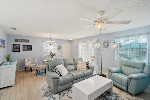 1728 Morelos Rd, The Villages, FL 32159 - living room with a textured ceiling, a chandelier, light wood-type flooring, baseboards, and a ceiling fan