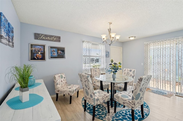 1728 Morelos Rd, The Villages, FL 32159 - dining room with a chandelier, light wood finished floors, healthy amount of natural light, and a textured ceiling