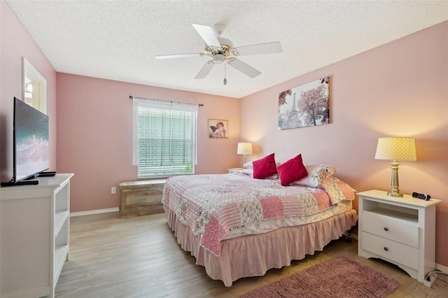 1728 Morelos Rd, The Villages, FL 32159 - bedroom featuring light wood finished floors, baseboards, a textured ceiling, and ceiling fan