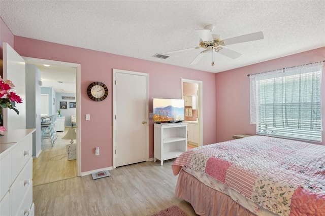 1728 Morelos Rd, The Villages, FL 32159 - bedroom with light wood-type flooring, a textured ceiling, baseboards, and a ceiling fan