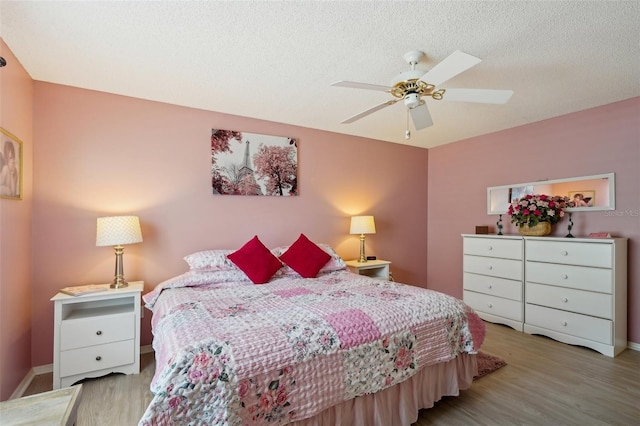 1728 Morelos Rd, The Villages, FL 32159 - bedroom with wood finished floors, a ceiling fan, a textured ceiling, and baseboards