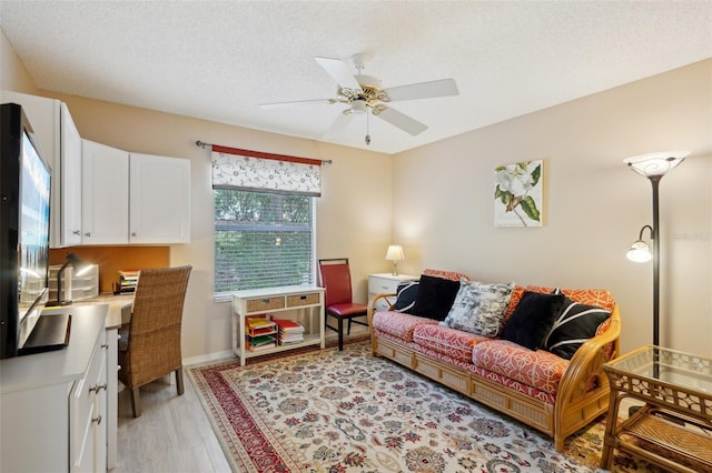 1728 Morelos Rd, The Villages, FL 32159 - living area featuring ceiling fan, light wood-style floors, a textured ceiling, and baseboards