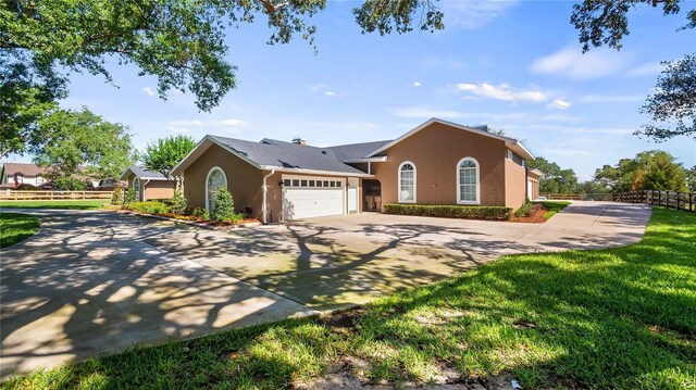 15245 Arabian Way, Montverde, FL 34756 - ranch-style house with concrete driveway, stucco siding, fence, and an attached garage