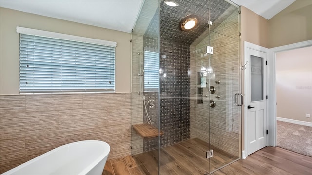 15245 Arabian Way, Montverde, FL 34756 - full bathroom with tile walls, a freestanding tub, a shower stall, wood finished floors, and vaulted ceiling