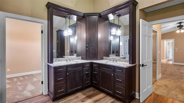 15245 Arabian Way, Montverde, FL 34756 - bathroom with double vanity, wood finished floors, a ceiling fan, baseboards, and vaulted ceiling