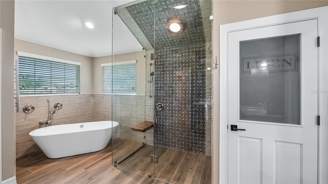 15245 Arabian Way, Montverde, FL 34756 - bathroom with tile walls, a soaking tub, a shower stall, and wood finished floors