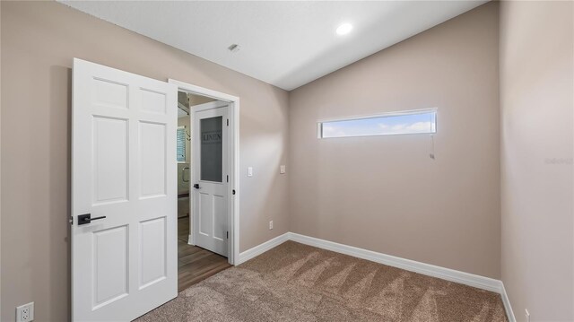 15245 Arabian Way, Montverde, FL 34756 - empty room featuring carpet floors, lofted ceiling, and baseboards