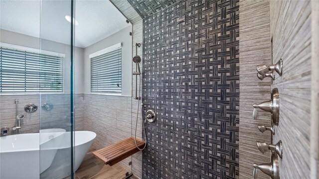 15245 Arabian Way, Montverde, FL 34756 - bathroom featuring tiled shower, a freestanding tub, tile walls, and a wainscoted wall