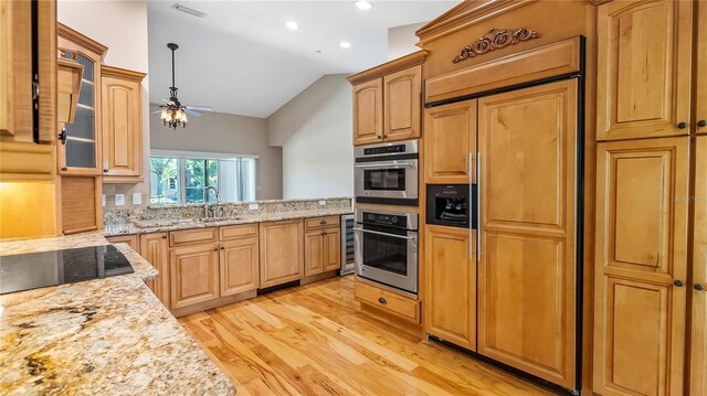 15245 Arabian Way, Montverde, FL 34756 - kitchen featuring paneled built in fridge, vaulted ceiling, light wood-style floors, a sink, and ceiling fan