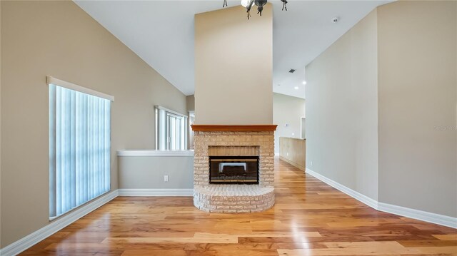 15245 Arabian Way, Montverde, FL 34756 - unfurnished living room featuring high vaulted ceiling, wood finished floors, baseboards, and a fireplace