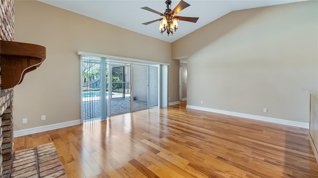 15245 Arabian Way, Montverde, FL 34756 - spare room with light wood-style floors, vaulted ceiling, ceiling fan, baseboards, and a fireplace