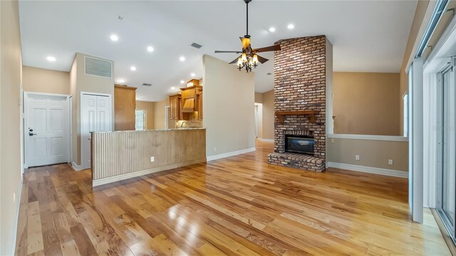 15245 Arabian Way, Montverde, FL 34756 - unfurnished living room featuring a ceiling fan, lofted ceiling, light wood-style floors, a brick fireplace, and baseboards