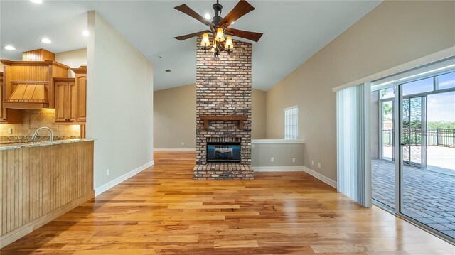 15245 Arabian Way, Montverde, FL 34756 - unfurnished living room featuring light wood-style floors, high vaulted ceiling, a ceiling fan, baseboards, and a fireplace