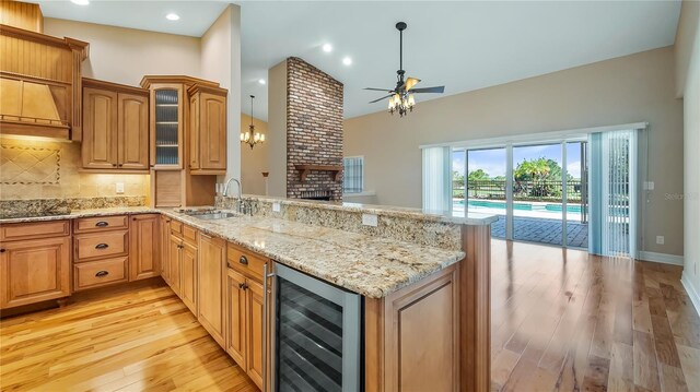 15245 Arabian Way, Montverde, FL 34756 - kitchen featuring beverage cooler, a peninsula, a ceiling fan, a sink, and light wood-style flooring
