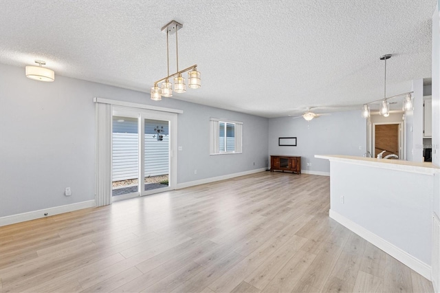 1615 Navidad St, The Villages, FL 32162 - unfurnished living room with a textured ceiling, ceiling fan, light wood-style floors, and baseboards