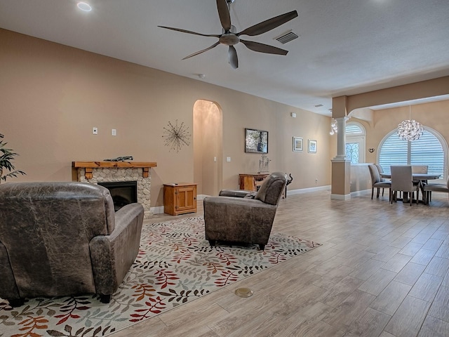 10994 SE 168th Loop, Summerfield, FL 34491 - living room with arched walkways, ceiling fan, light wood-style flooring, a fireplace, and baseboards