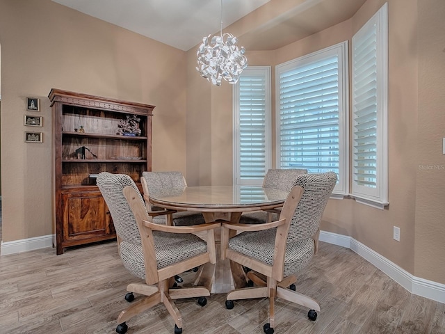 10994 SE 168th Loop, Summerfield, FL 34491 - dining area featuring light wood-style flooring, baseboards, and a chandelier