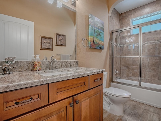 10994 SE 168th Loop, Summerfield, FL 34491 - full bathroom with toilet, wood finished floors, vanity, and shower / bath combination with glass door