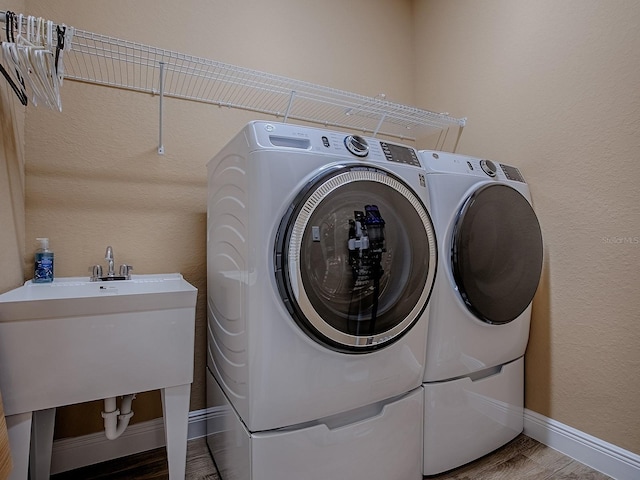 10994 SE 168th Loop, Summerfield, FL 34491 - clothes washing area featuring washer and clothes dryer, baseboards, and wood finished floors