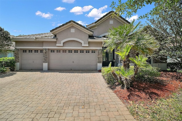 926 Wood Briar Loop, Sanford, FL 32771 - view of front of property with stucco siding, decorative driveway, an attached garage, and stone siding
